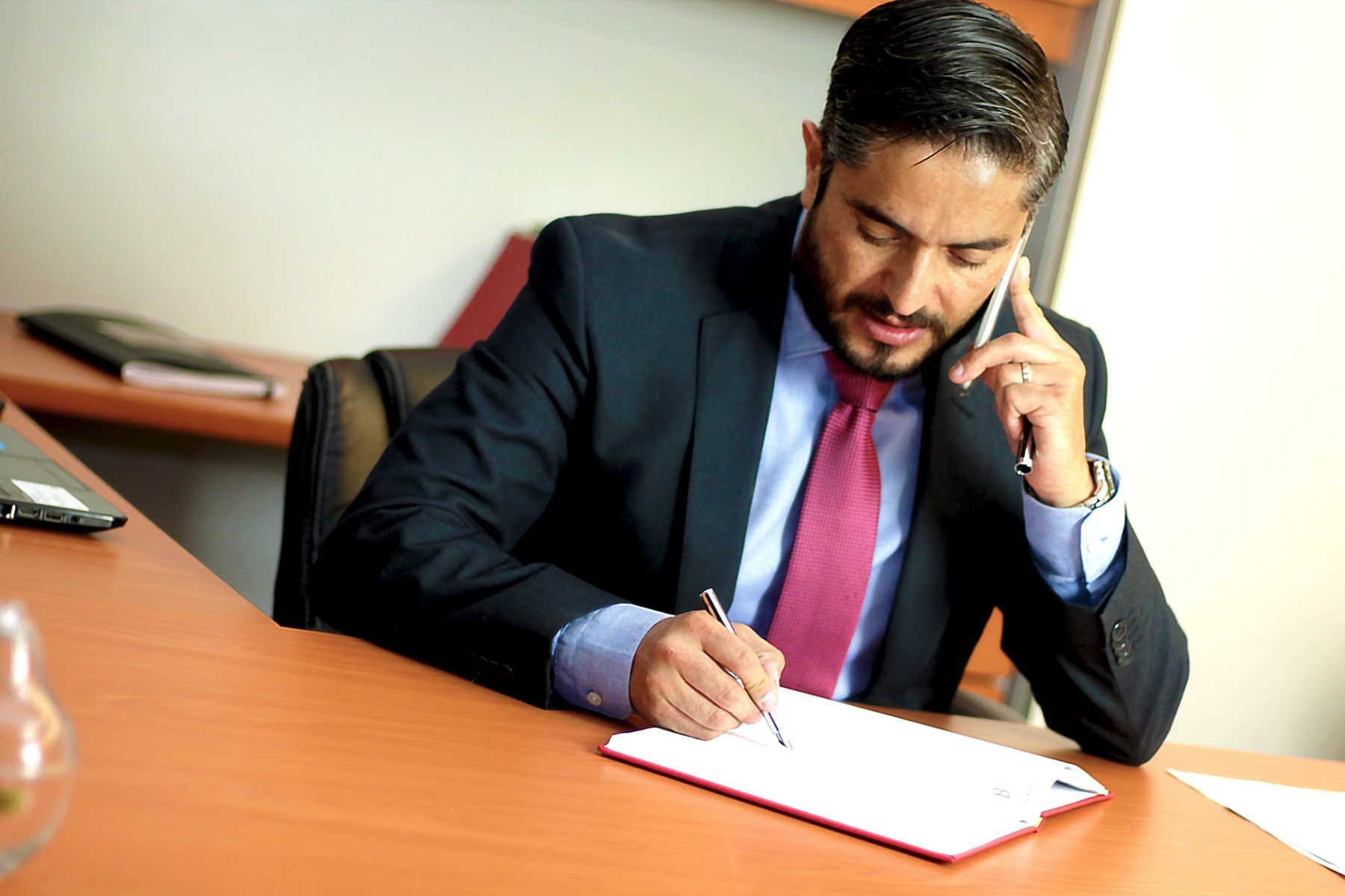 Avvocato al telefono mentre prende appunti